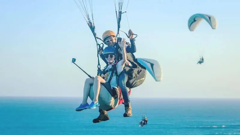 Tandem paragliding di atas laut selatan Sawangan, Nusa Dua