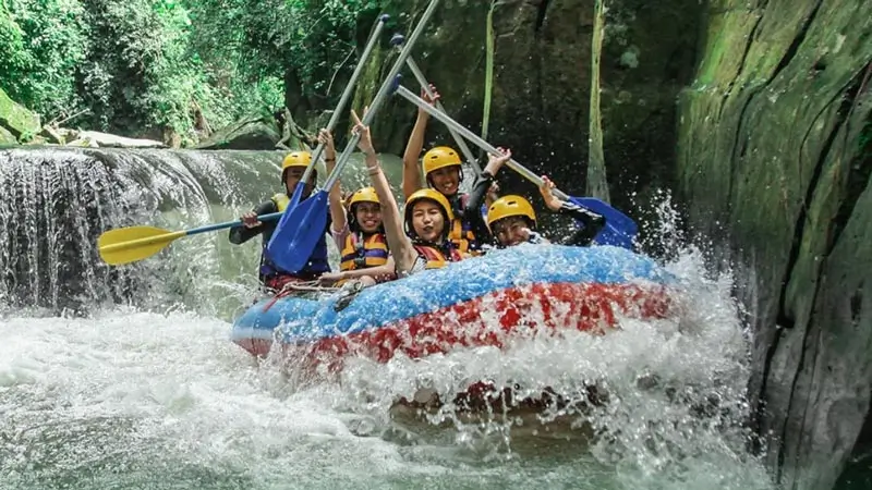 Peserta rafting melewati arus deras di jalur sempit berbatu