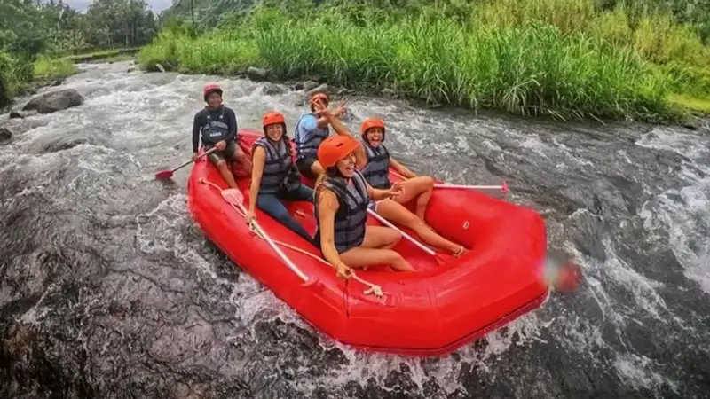 Peserta arung jeram di perahu merah saat melintasi sungai