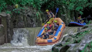 Melangit River Rafting melewati turunan kecil di sungai berbatu