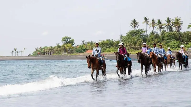 Wisatawan naik kuda di pantai Bali