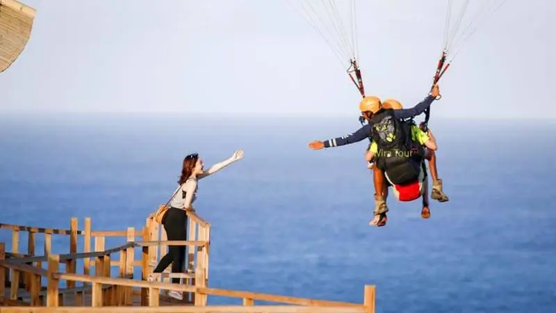 Tandem paragliding dengan pemandangan laut Bali