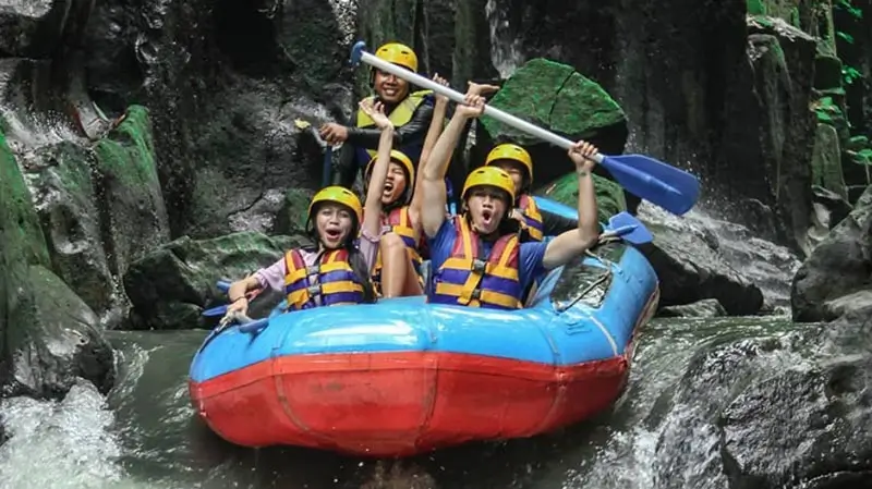 Peserta rafting melewati jeram sempit di antara tebing batu
