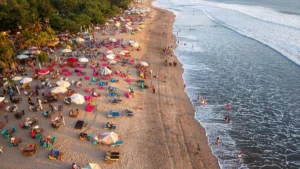 Garis Pantai Kuta Bali dengan pasir, ombak, dan wisatawan