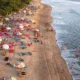 Garis Pantai Kuta Bali dengan pasir, ombak, dan wisatawan