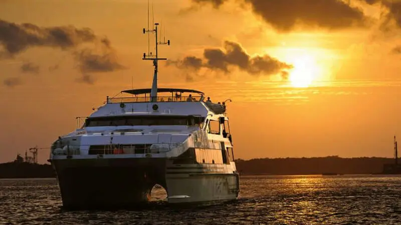 Kapal cruise berlayar saat matahari terbenam