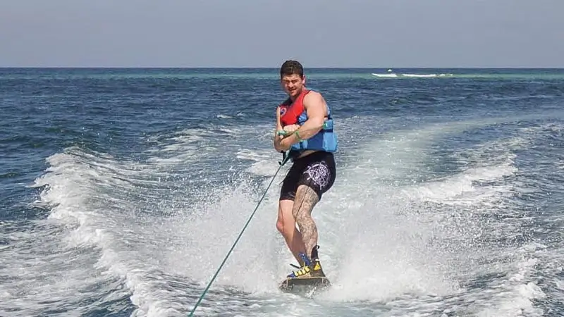 Peserta memegang tali penarik saat bermain wakeboarding di laut Tanjung Benoa